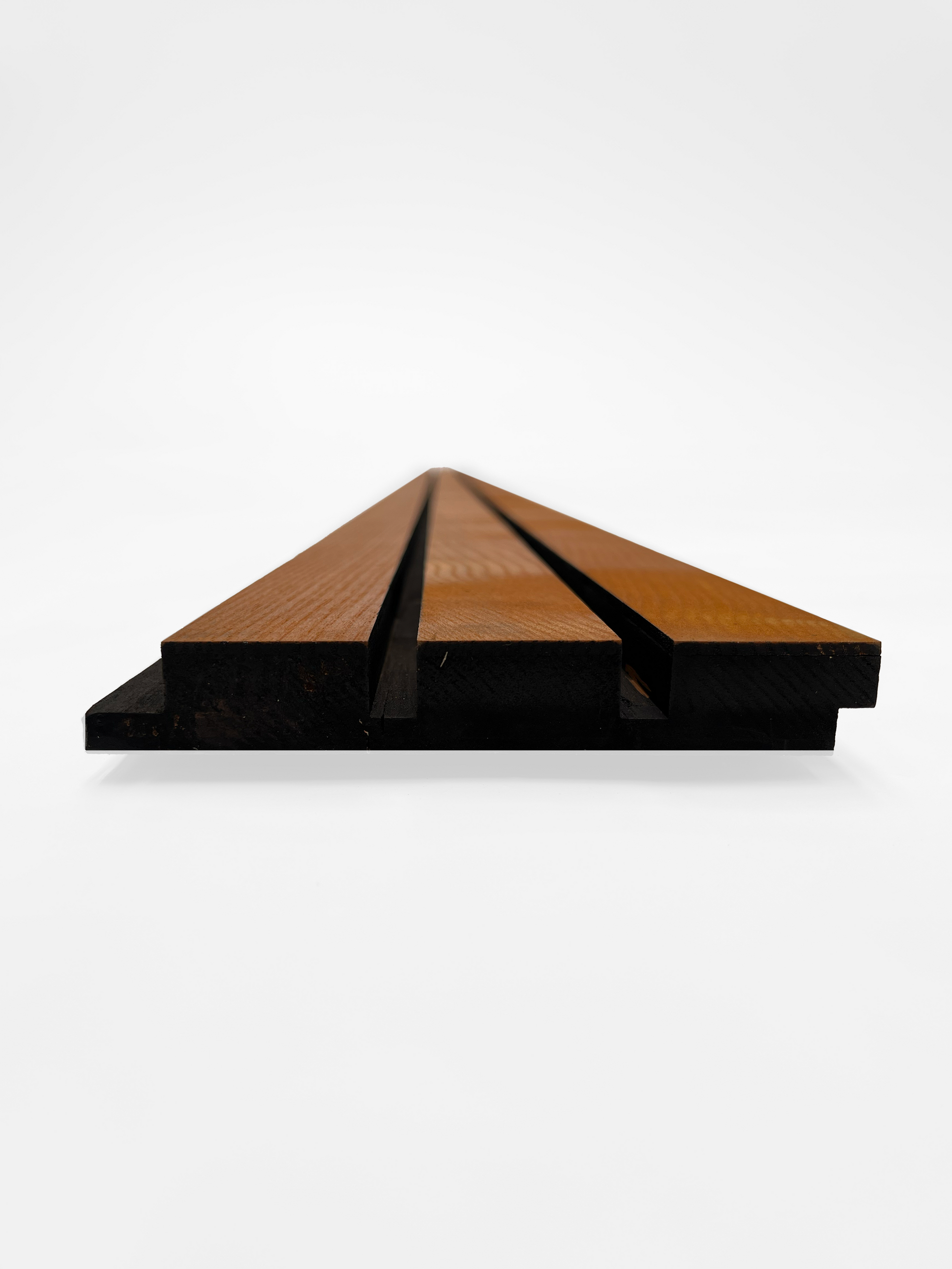 A straight-on view of a wooden facade board featuring parallel grooves, highlighting the board’s layered structure. The board has a dark underside and lighter wood slats on top, emphasizing its sleek and minimalist design against a plain white background