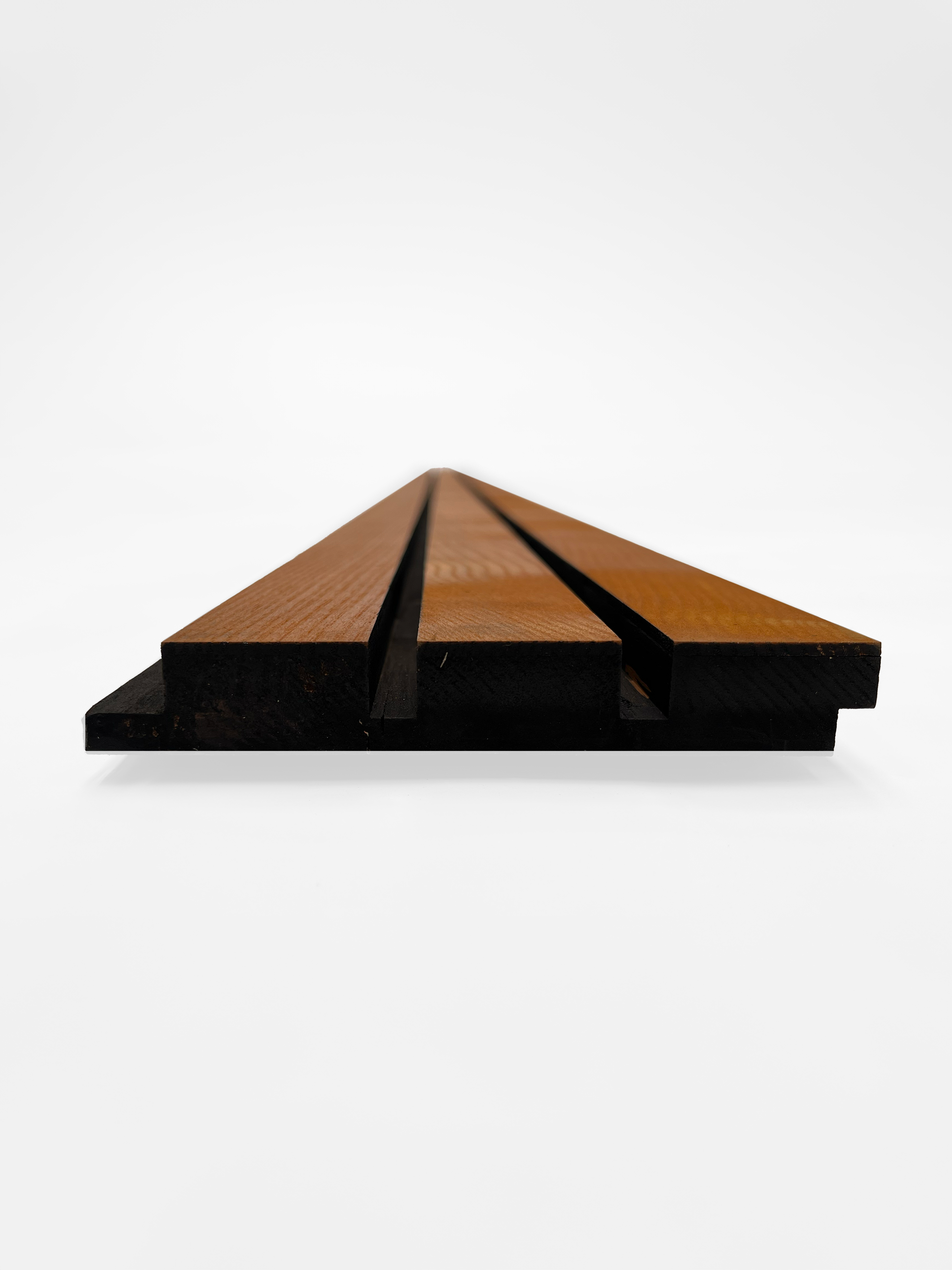 A straight-on view of a wooden facade board featuring parallel grooves, highlighting the board’s layered structure. The board has a dark underside and lighter wood slats on top, emphasizing its sleek and minimalist design against a plain white background